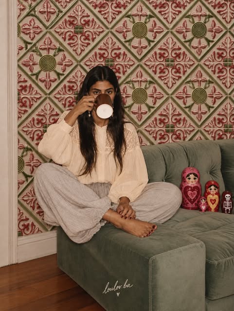 Modelo tomando té en sillón verde